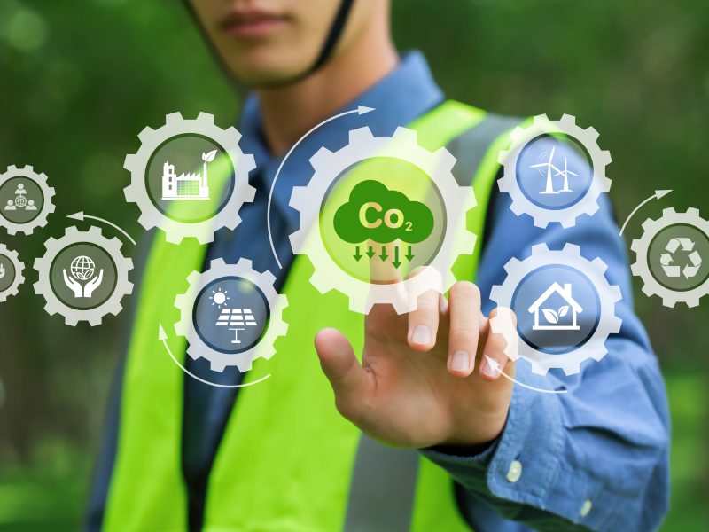 environmental engineering touching green CO2 icon and green icon on a green background. Renewable energy-based green businesses can limit climate change and global warming. Reduce CO2 emission.